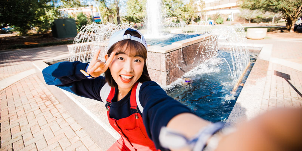 female student posing by the uwg fountain 